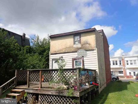 rear view of property with a deck and a lawn