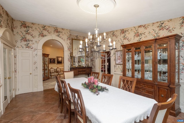 dining room with dark tile flooring and a chandelier