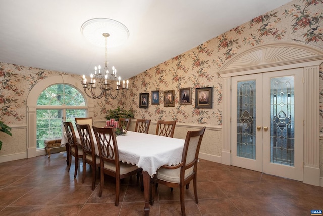 tiled dining space with a notable chandelier, french doors, and lofted ceiling