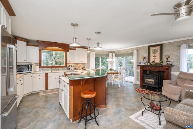 kitchen with white cabinets, a healthy amount of sunlight, and pendant lighting