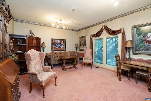 living area featuring light colored carpet and a chandelier