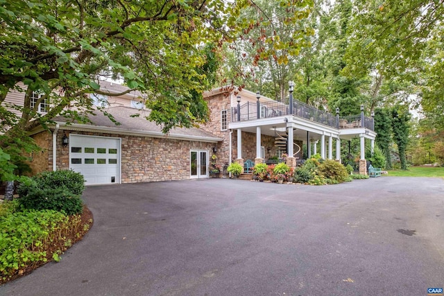 view of front of property featuring a balcony and a garage