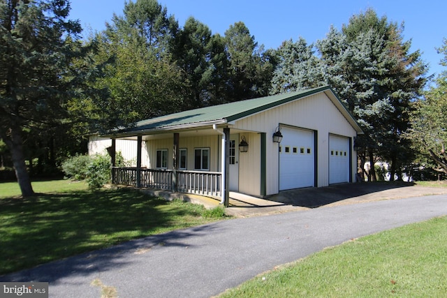 view of front of property with covered porch, a front lawn, and a garage