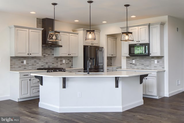 kitchen with dark wood-type flooring, decorative backsplash, an island with sink, fridge with ice dispenser, and wall chimney range hood