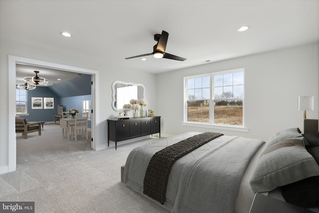 bedroom featuring light colored carpet and ceiling fan with notable chandelier