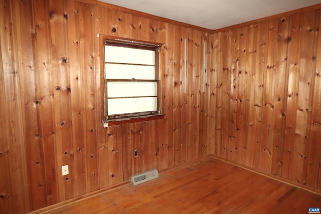 spare room with wooden walls and hardwood / wood-style flooring