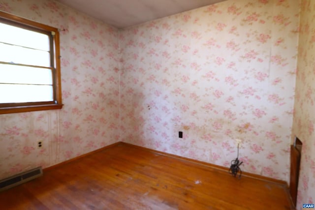 spare room featuring hardwood / wood-style floors and a baseboard radiator