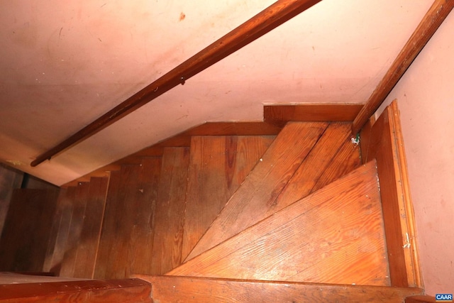 stairway featuring wooden walls