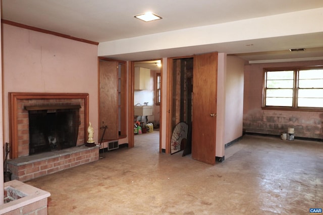 unfurnished living room with a brick fireplace and sink