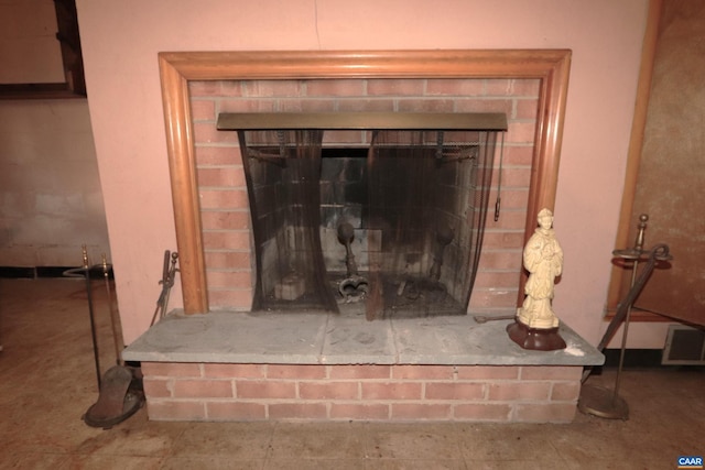 interior details featuring a brick fireplace