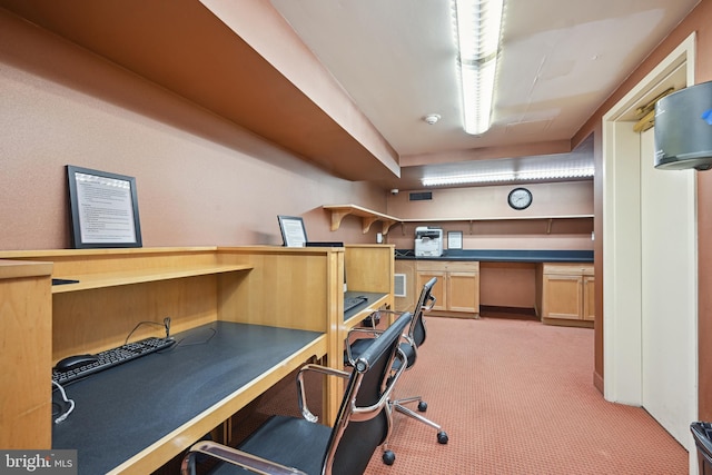 carpeted home office featuring built in desk