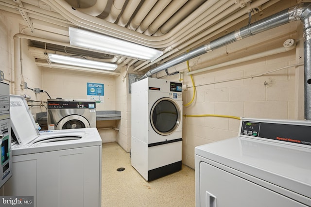 clothes washing area with washer and clothes dryer