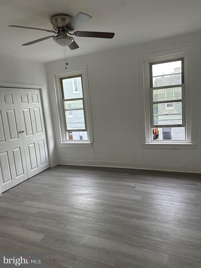 unfurnished bedroom with ceiling fan, a closet, and light hardwood / wood-style floors