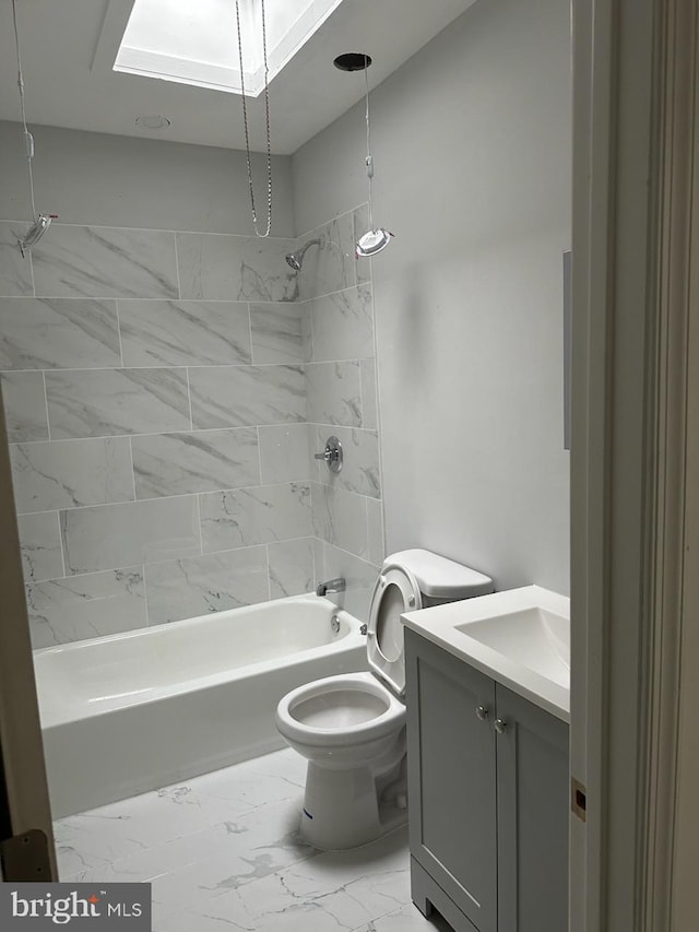 full bathroom featuring tiled shower / bath combo, a skylight, toilet, vanity, and tile floors