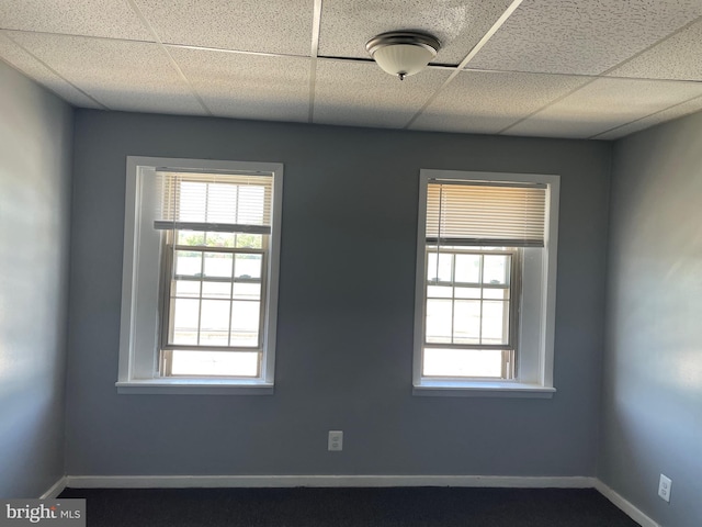 unfurnished room featuring a drop ceiling