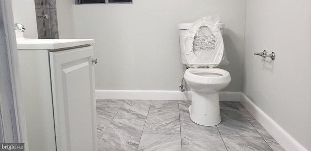 bathroom featuring tile floors, toilet, and vanity