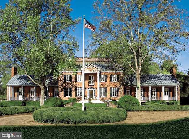 rear view of property featuring a porch and a lawn