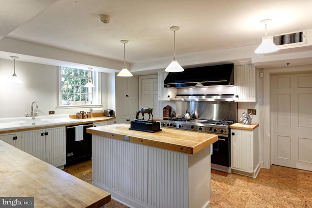 kitchen with butcher block countertops, black dishwasher, white cabinets, double oven range, and wall chimney range hood