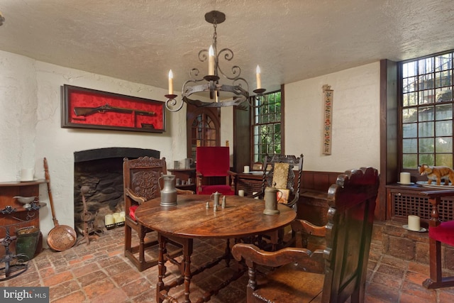 tiled dining area with a notable chandelier and a textured ceiling