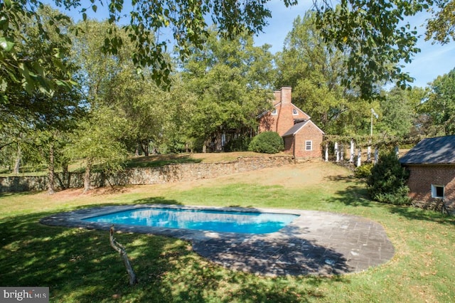 view of swimming pool featuring a yard