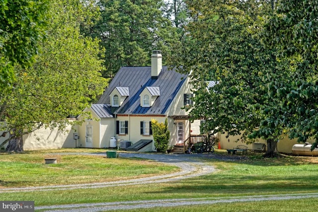 view of front of property with a front yard and central AC