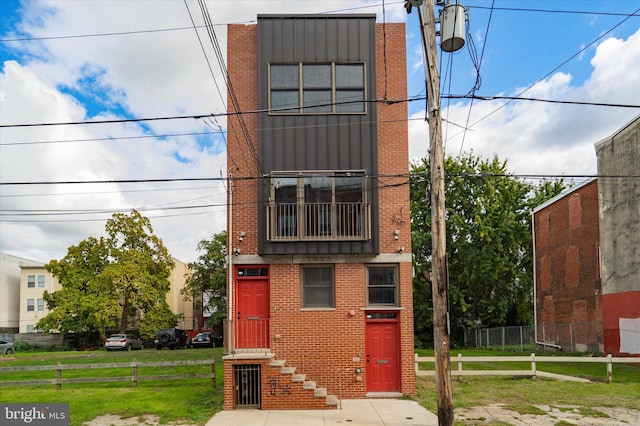 view of front of house with a front yard and a balcony