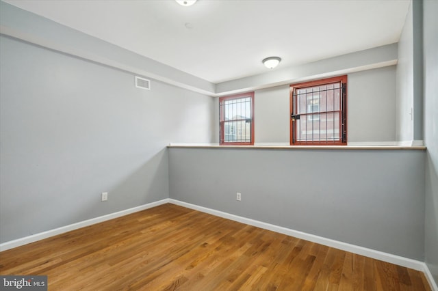 unfurnished room with hardwood / wood-style floors