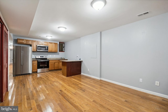 kitchen featuring stainless steel appliances and light hardwood / wood-style flooring