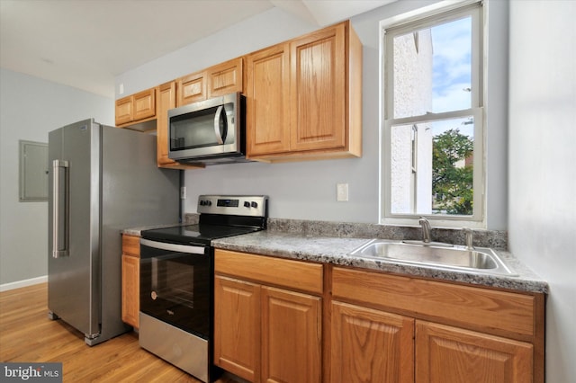 kitchen featuring appliances with stainless steel finishes, light wood-type flooring, and sink