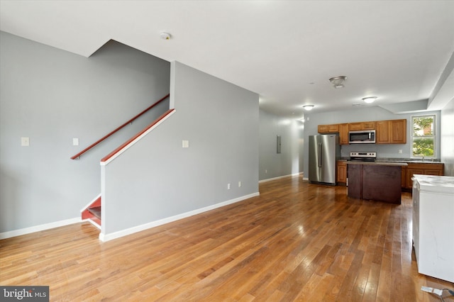 unfurnished living room featuring light hardwood / wood-style flooring and sink