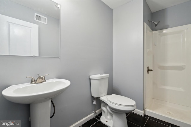 bathroom featuring walk in shower, tile floors, and toilet