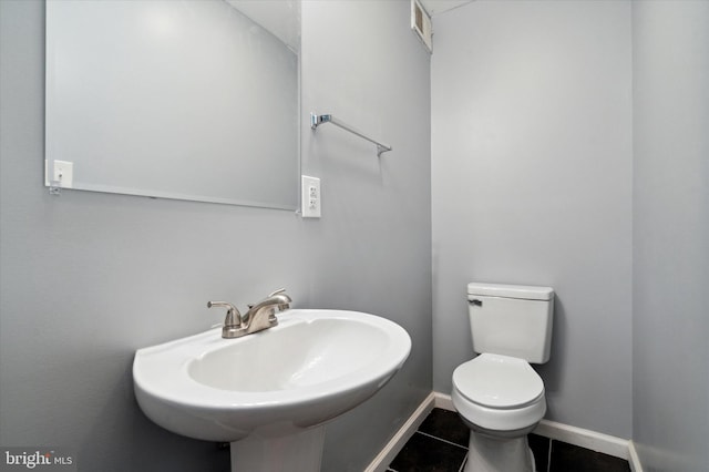 bathroom with toilet, tile floors, and sink