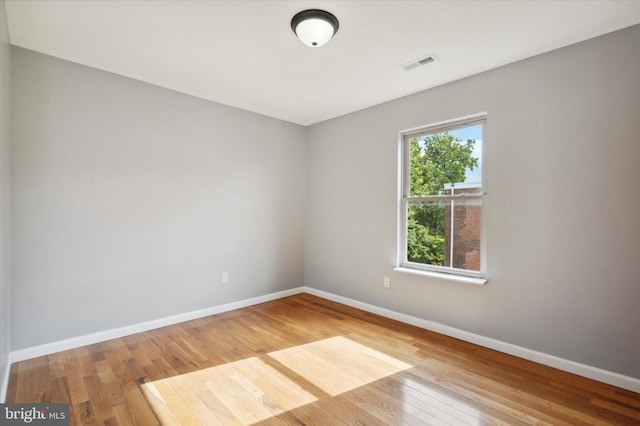 spare room featuring a healthy amount of sunlight and light hardwood / wood-style floors