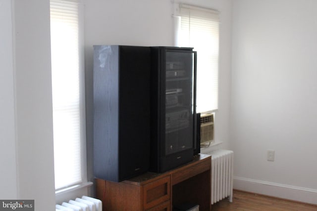 home office with hardwood / wood-style floors and radiator