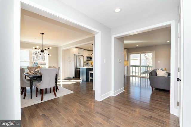 dining space featuring dark wood-type flooring and a chandelier