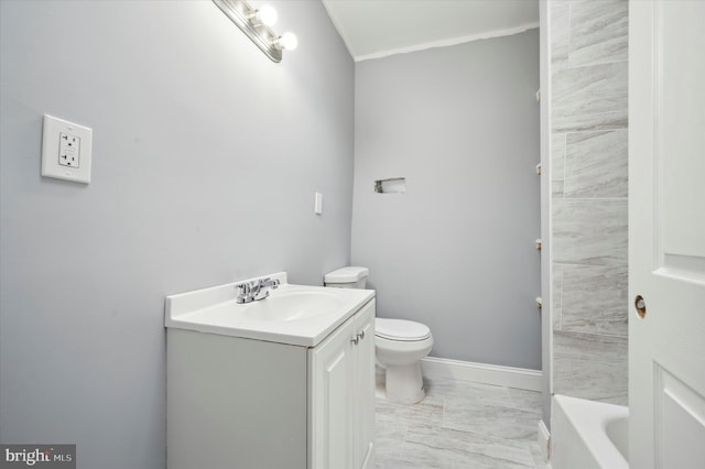 bathroom featuring vanity, toilet, and a tub to relax in