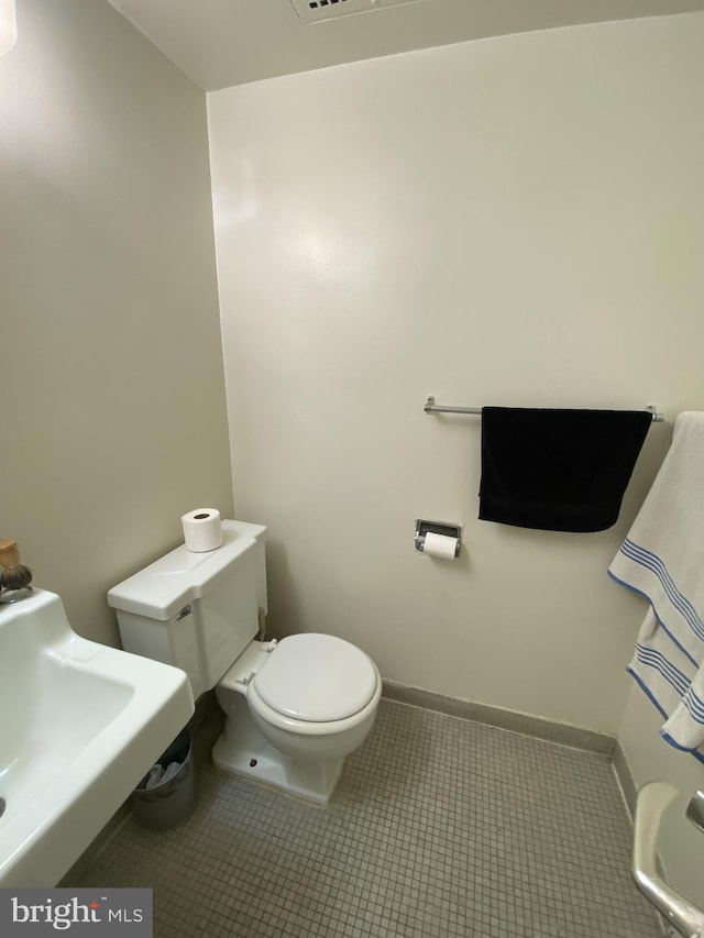 bathroom with toilet and tile patterned flooring