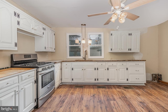 kitchen featuring ceiling fan, sink, hardwood / wood-style flooring, gas stove, and white cabinets