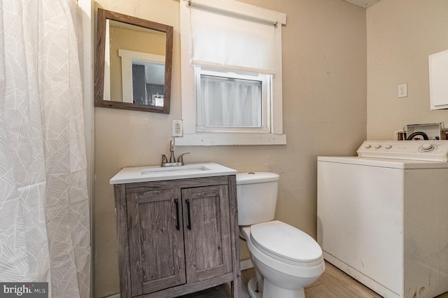 bathroom with washer / dryer, toilet, and vanity