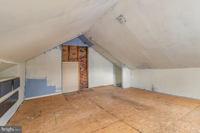 additional living space with brick wall and vaulted ceiling