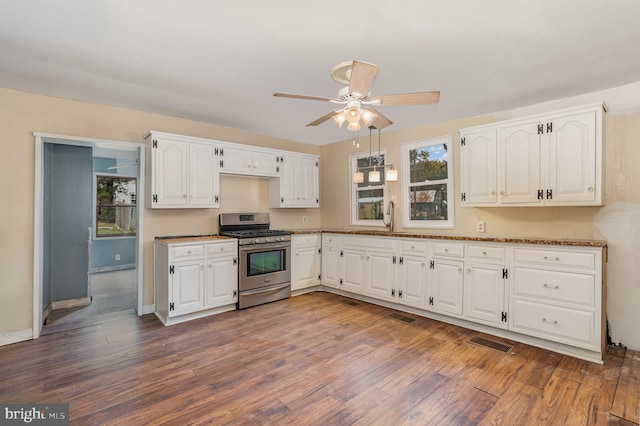 kitchen featuring white cabinetry, a wealth of natural light, ceiling fan, and stainless steel gas stove