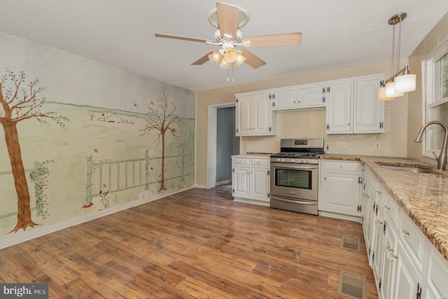 kitchen featuring sink, ceiling fan, stainless steel range with gas stovetop, and white cabinetry