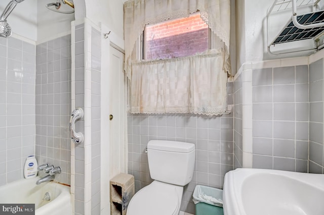 bathroom featuring toilet and tile walls