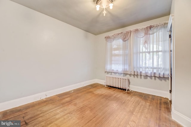 empty room featuring light hardwood / wood-style floors and radiator heating unit