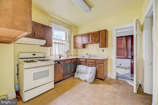 kitchen featuring light tile flooring, white range oven, and sink