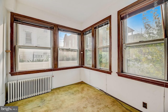 unfurnished sunroom with radiator heating unit