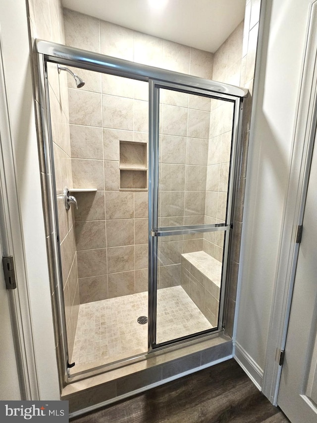 bathroom with an enclosed shower and wood-type flooring