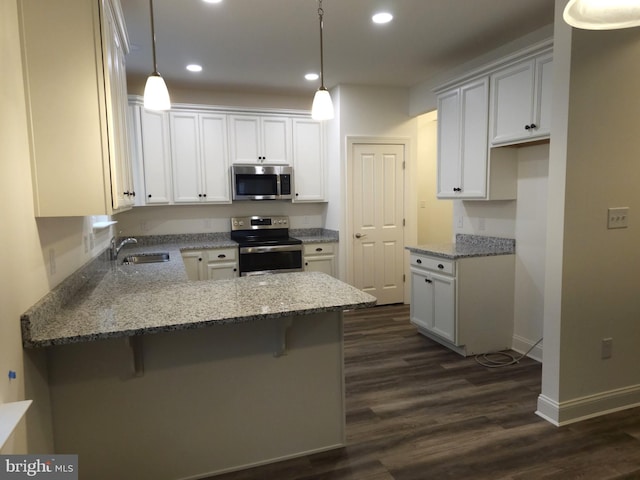 kitchen featuring a kitchen bar, pendant lighting, and stainless steel appliances