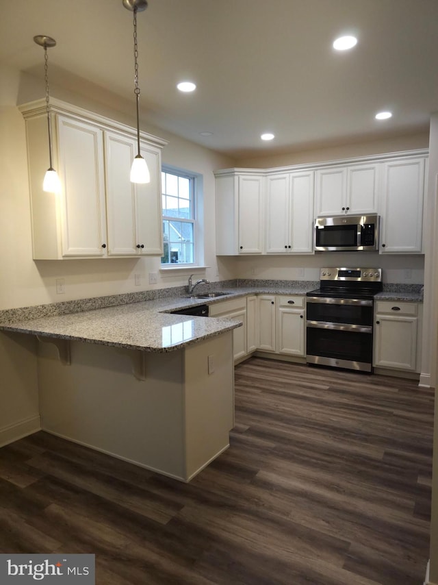 kitchen featuring kitchen peninsula, hanging light fixtures, stainless steel appliances, and dark wood-type flooring