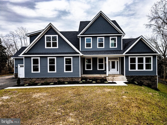 craftsman inspired home with a garage, a front lawn, and covered porch